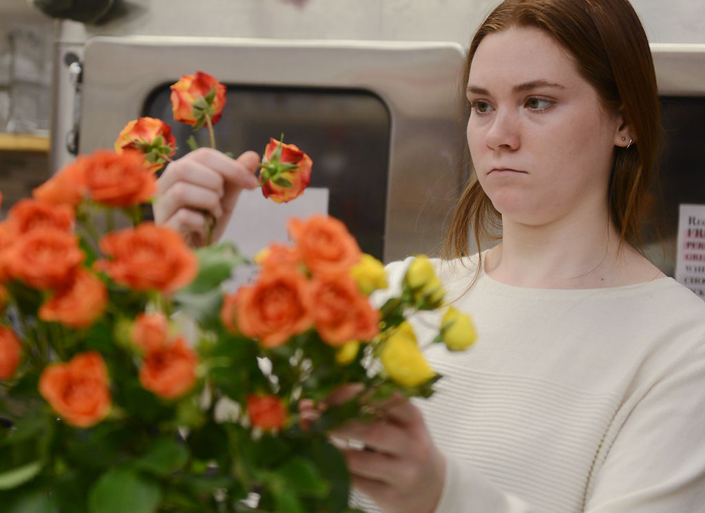 Amara Limberis deliberates over a floral arrangement